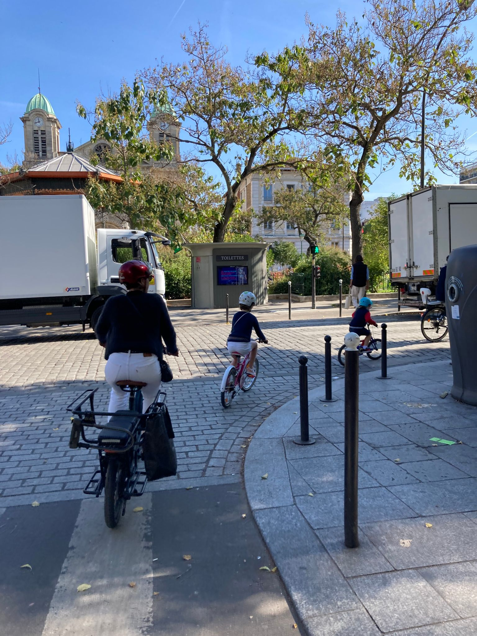 自転車に乗った子どもと大人が三差路を曲るところの写真