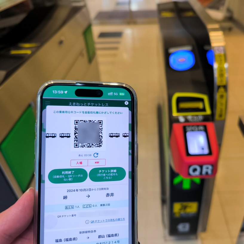 QRコードを表示しているスマホと改札機の写真です。
