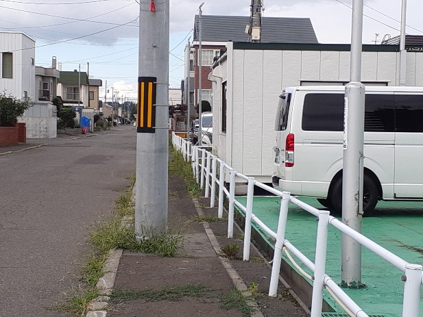 狭い歩道に電柱が立っている所の写真です。