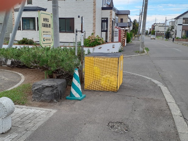 歩道に大きな四角いごみ箱があるところの写真です。