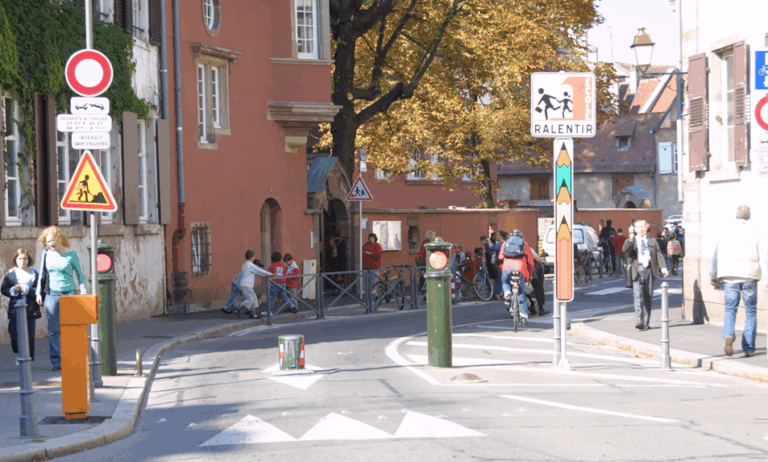 ライジングボラードが設置された道を人や自転車が行き交う様子の写真です。