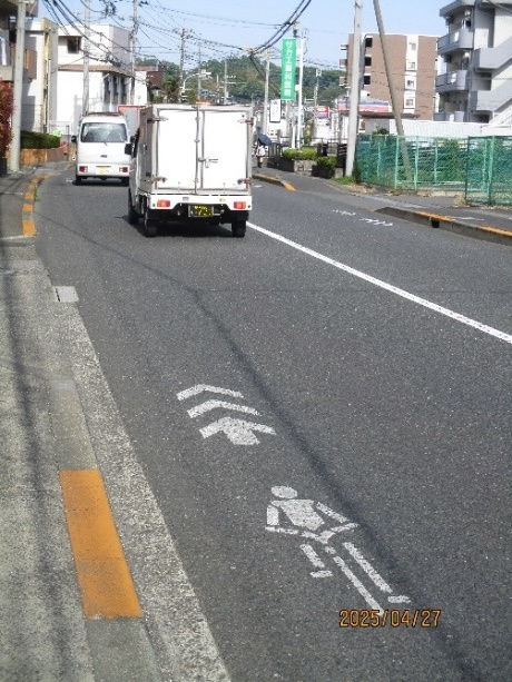 自転車マークが路面に描かれた道路の写真です。クルマは道の中央寄りを走っています。