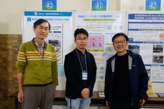 当会展示ポスターの前に立つ当会会員たち