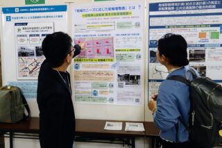 壁に貼られた当会ポスターを見る参加者たち