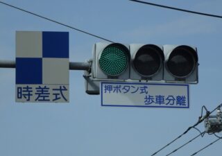 「時差式、押ボタン式・歩車分離」と標示された信号機です。