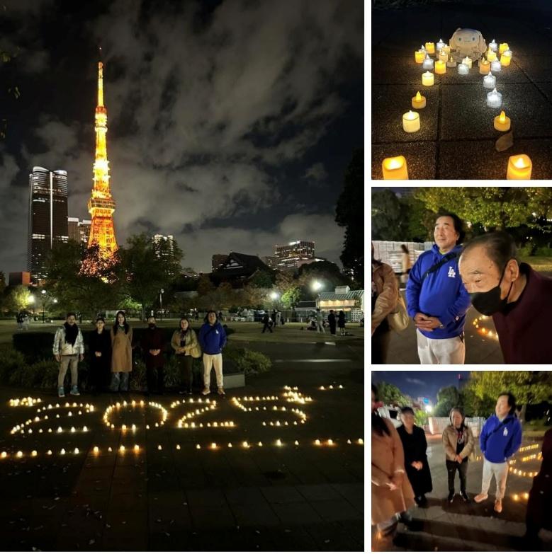 並べたキャンドルの前に立つ人々。背景に東京タワーが見えます。